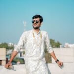 A stylish man in traditional Indian clothing posing confidently on a rooftop in Indore.